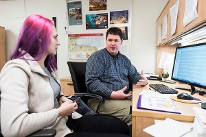 Photo of Brian Asen, biology advisor in the Department of Bacteriology, meeting with a student in his office.