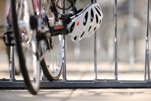 A bike and helmet are shown locked to a bike rack.