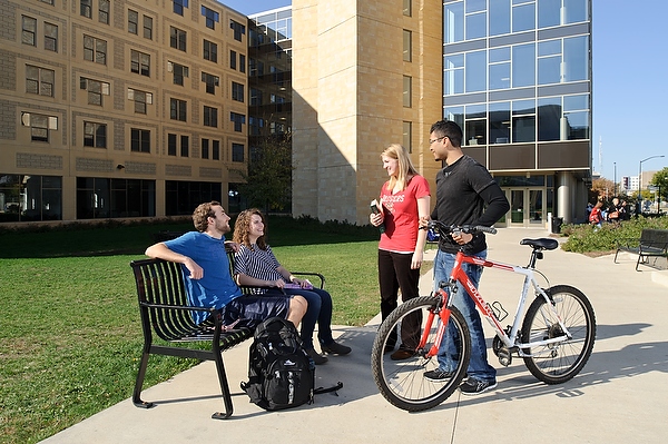 Students socialize in front of Ogg Hall on a sunny autumn morning.