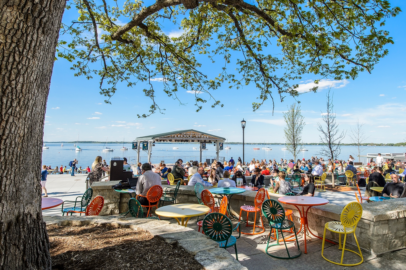Visitors enjoy the Memorial Union Terrace on a warm spring day, Lake Mendota in the background.