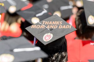 A graduating student's mortarboard reads "Thanks Mom and Dad!"