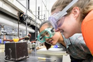 Two students watch their lab experiment closely in a summer term lab session of Organic Chemistry.