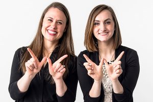 Stephanie Benson-Gonzales and Monica Ruppert of the Parent and Family Program, displaying the “w” sign.