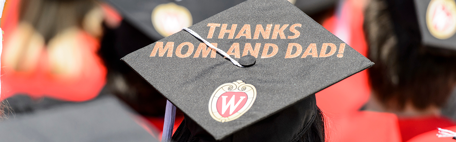 Graduates display personal messages on their graduation caps during UW-Madison's spring commencement ceremony at Camp Randall Stadium.