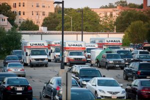 Moving trucks and SUVs taking advantage of the free parking in Lot 91 on moving day.