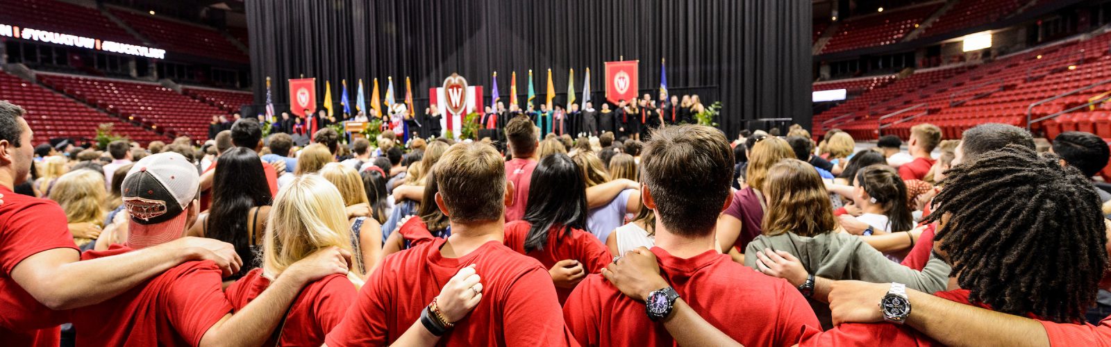 Students link arms and sing "Varsity" at the end of the Chancellor's Convocation for New Students.
