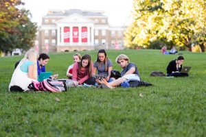 A group of students relax and study on Bascom Hill in autumn.