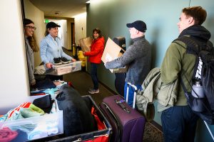 Parents and their students say goodbye to friends as they move items out of the dorm.
