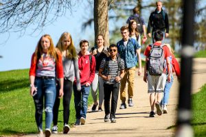 UW students walk along a pathway near Observatory Hill on a warm spring day.