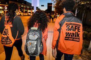 SAFEwalk staff walk with a student to a campus location at night.