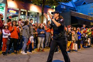 Police Chief Kristen Roman walks down State Street in the UW Homecoming parade, cheered on by the crowd.