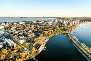 Aerial photograph of downtown Madison in autumn – an urban isthmus surrounded by lakes.