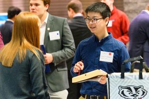 A student talks with a recruiter during a spring Career and Internship Fair held at the Kohl Center.