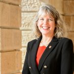 Lori Reesor, vice chancellor for student affairs, smiles while standing in front of the cream pillars of Bascom Hall.