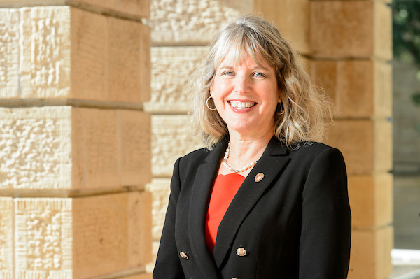 Lori Reesor, vice chancellor for student affairs, smiles while standing in front of the cream pillars of Bascom Hall.