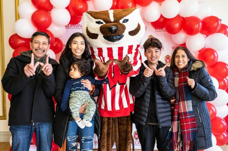 Second from left, UW–Madison senior Karen Bobadilla and her extended family, all from Fond du Lac, Wis., pose for a photo with Bucky Badger.