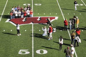 Family Weekend participants pose for photos on the football field at the Camp Randall Stadium.