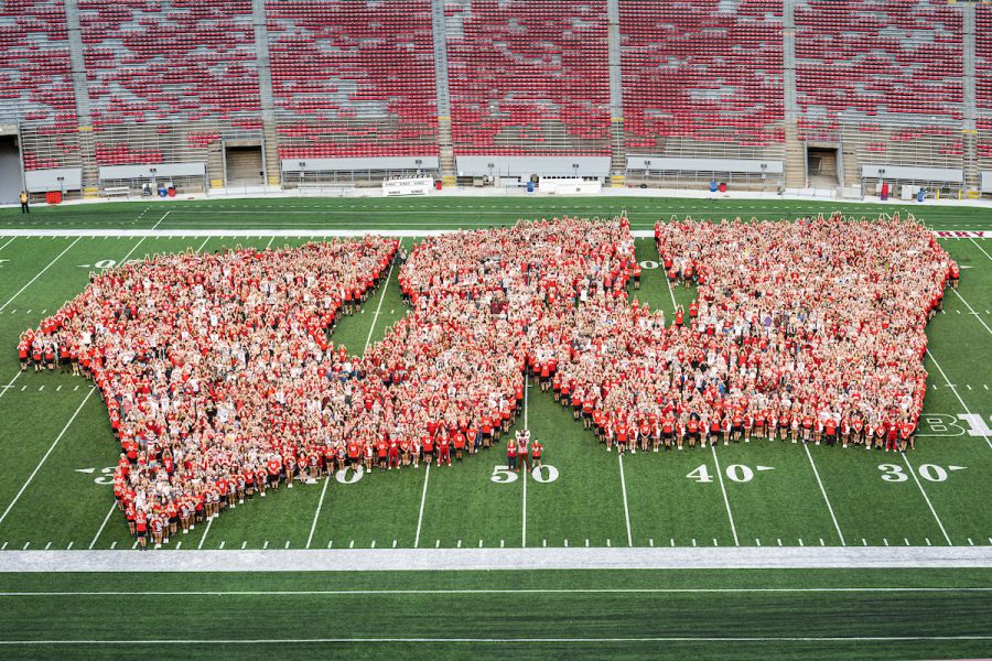 First-year students, along with UW mascot Bucky Badger and Chancellor Mnookin form the shape of an iconic Motion W as part of the W Project on the Camp Randall Stadium field.