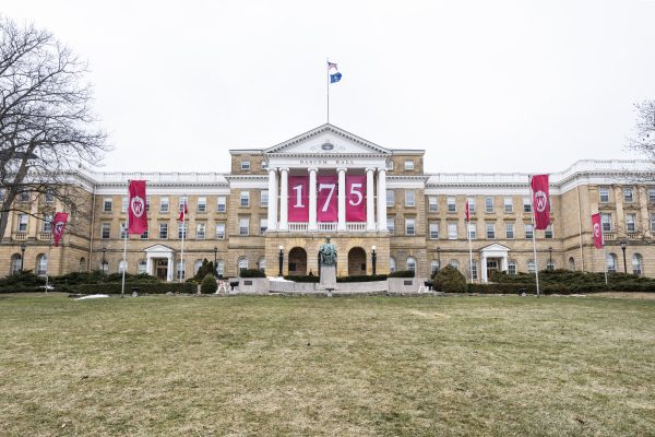 Red signs with 175 and UW logo hang in the Bascom Hall columns