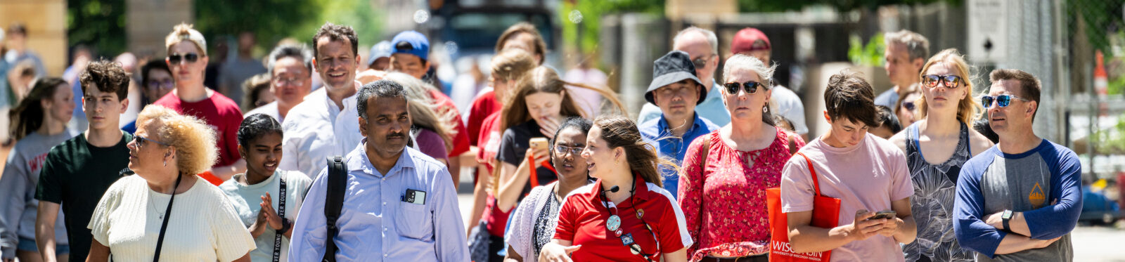 A wide shot of parents, family, and friends walking on campus