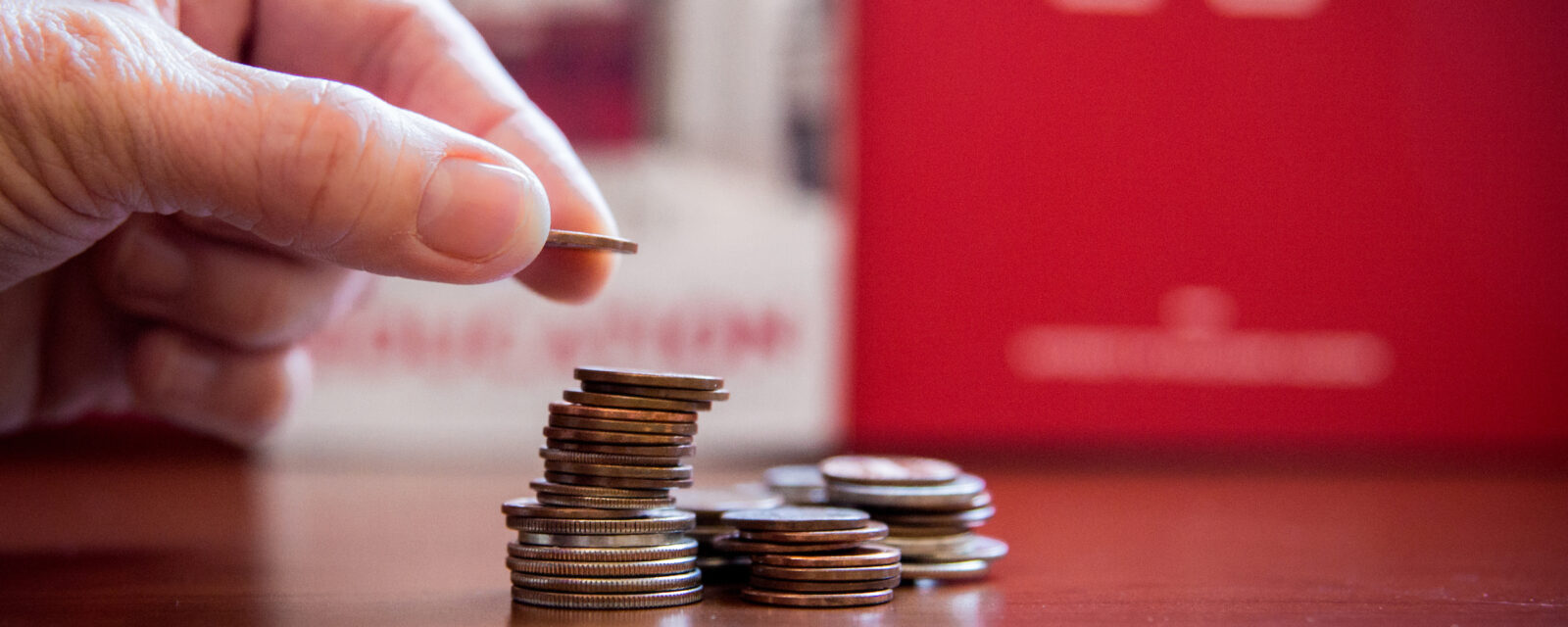 Picture of a hand counting out a stack of coins