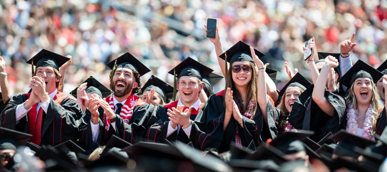 Graduates stand and celebrate as their degrees are conferred during UW–Madison's spring commencement ceremony at Camp Randall Stadium