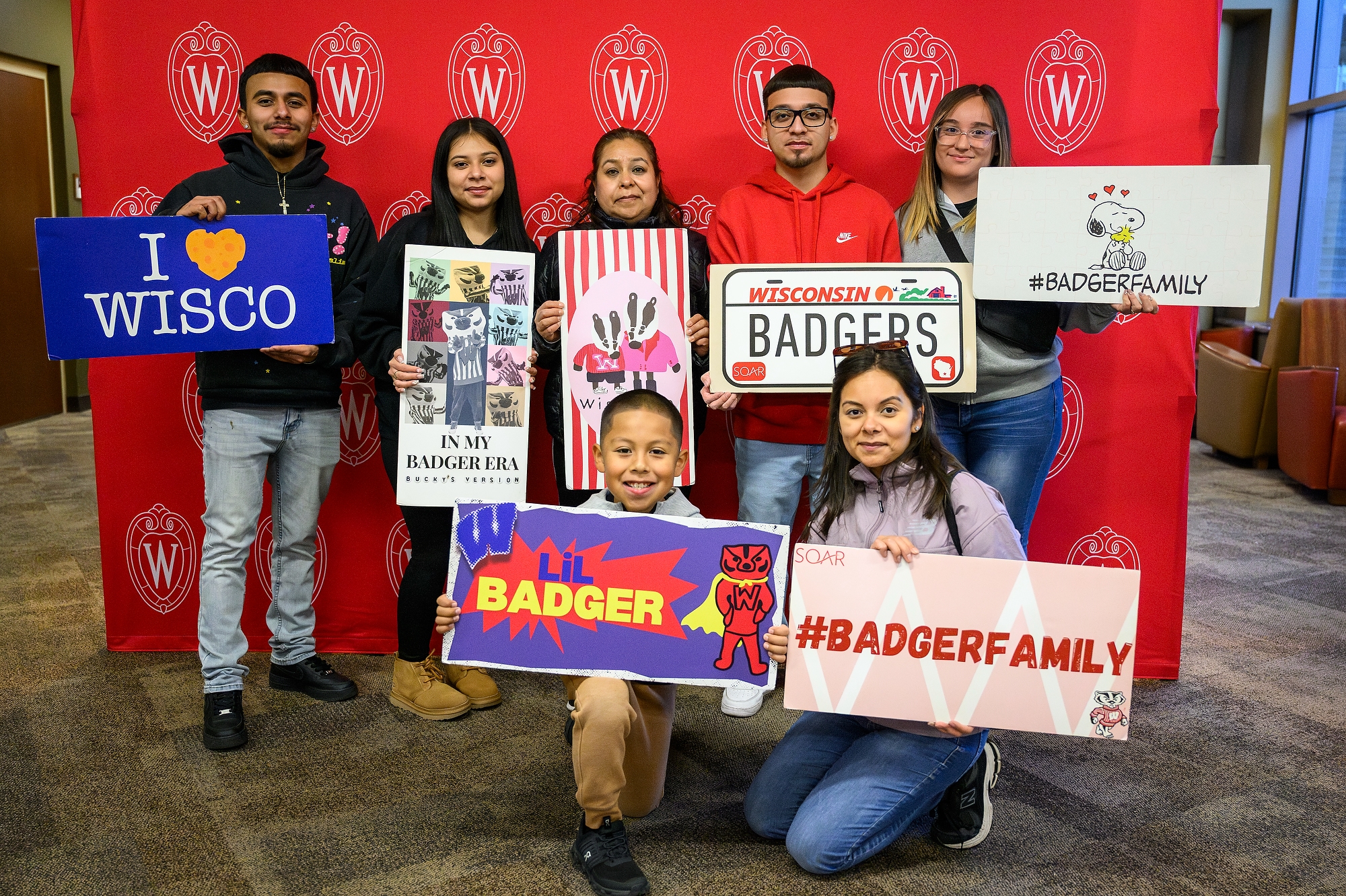 A family holds up signs