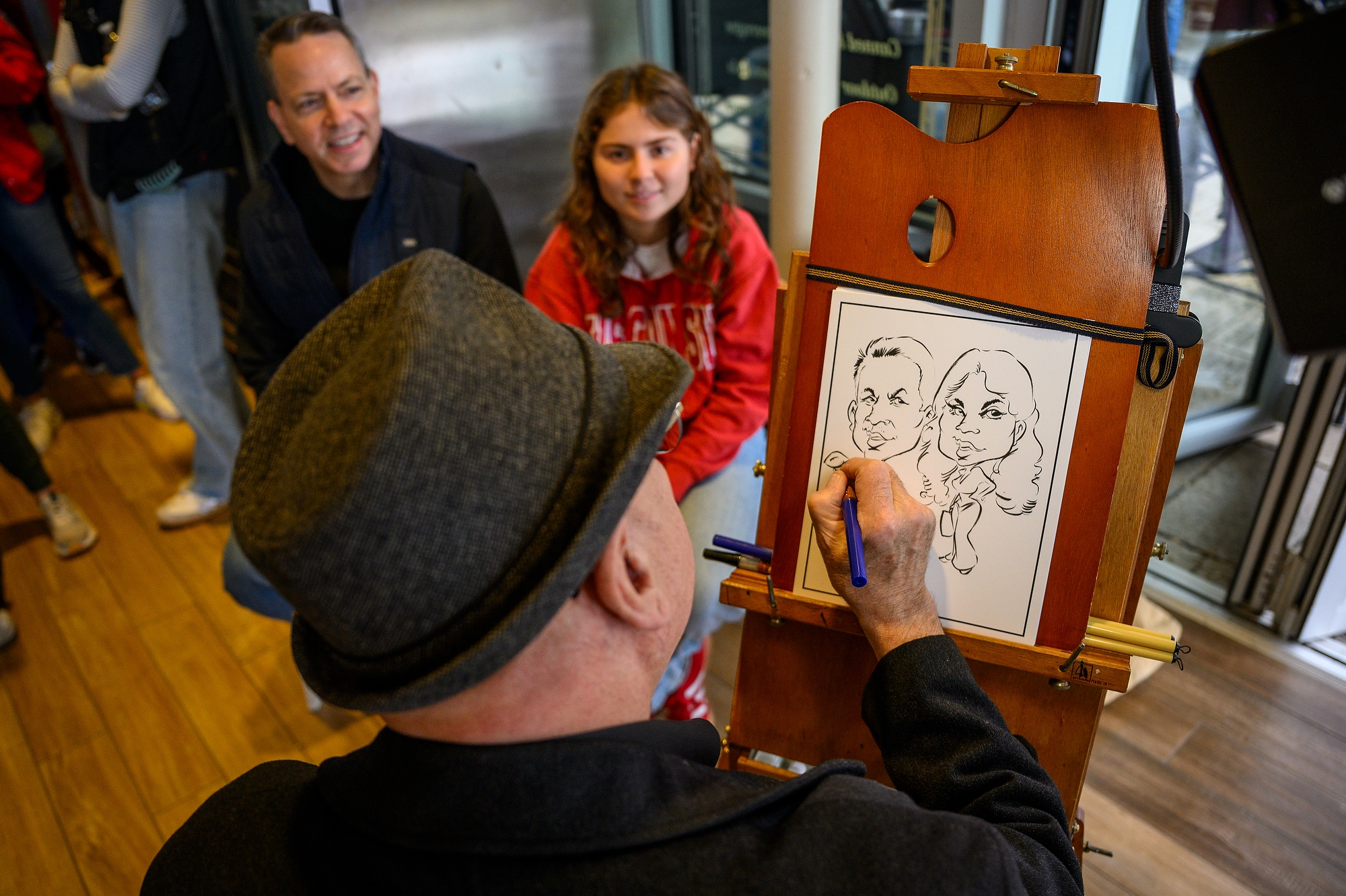 A caricature artist draws a dad and daughter