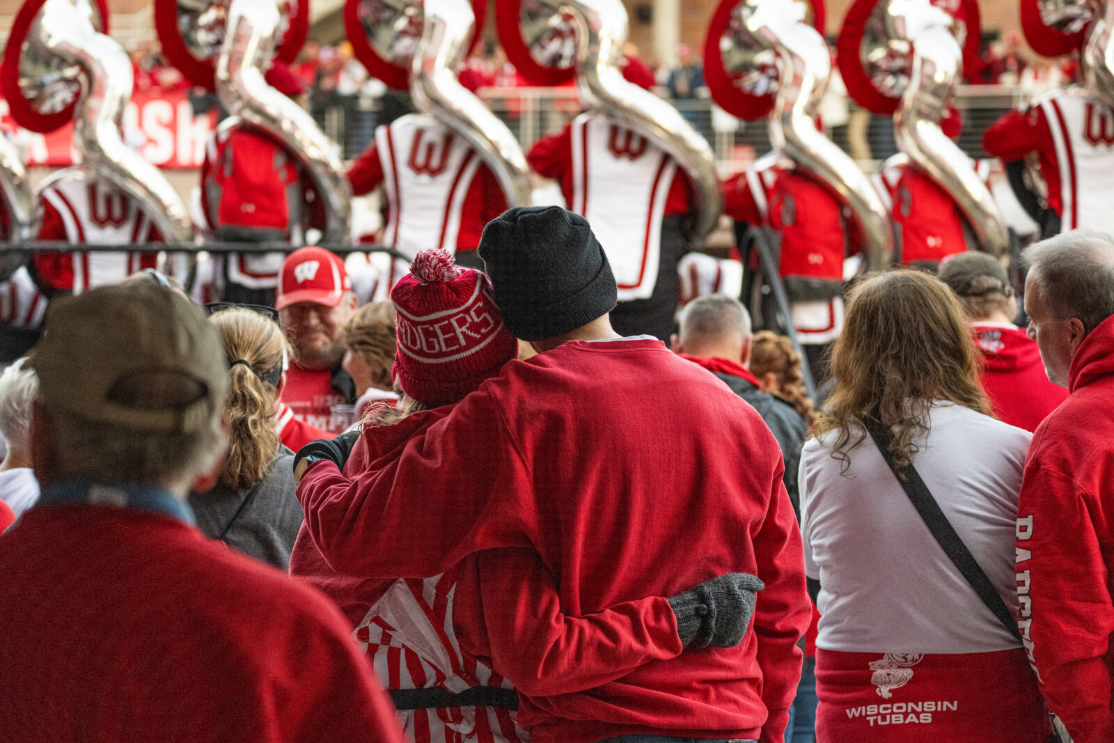 A couple watches the Badger Band play at a football game.