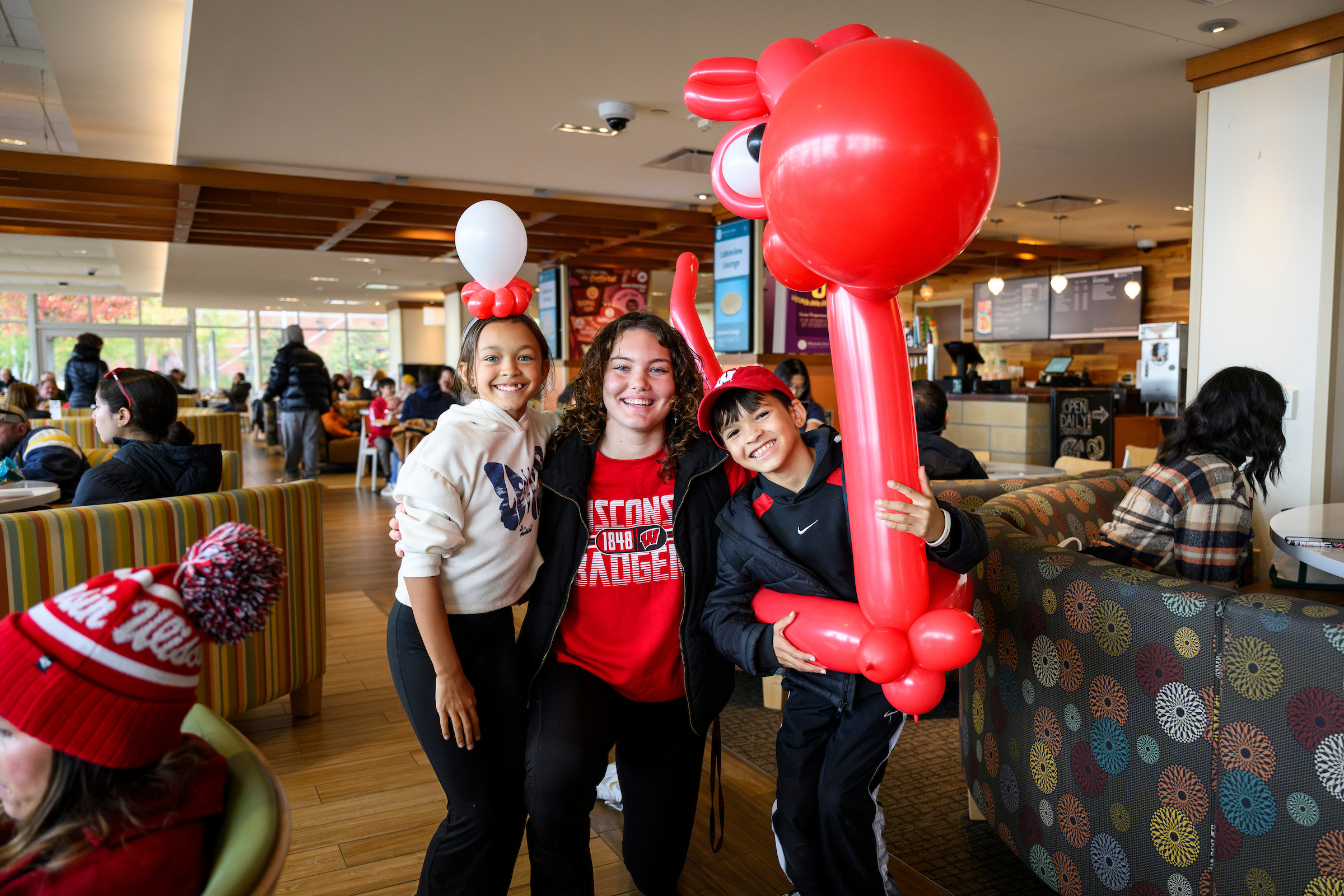 A family poses with a red balloon
