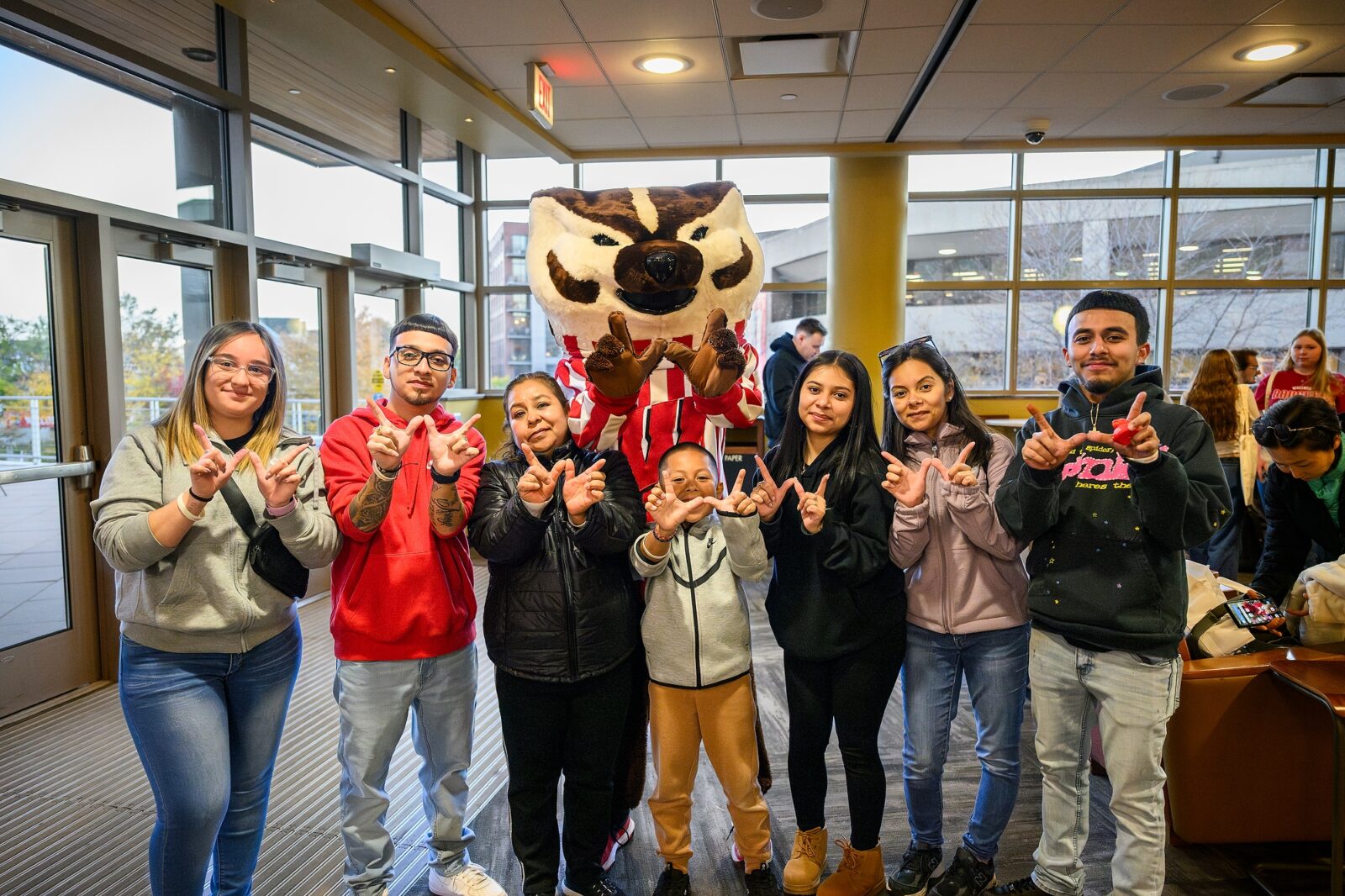 Student poses for a photo with Bucky and her family. 